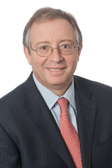 Man in coat and tie with gray hair and glasses