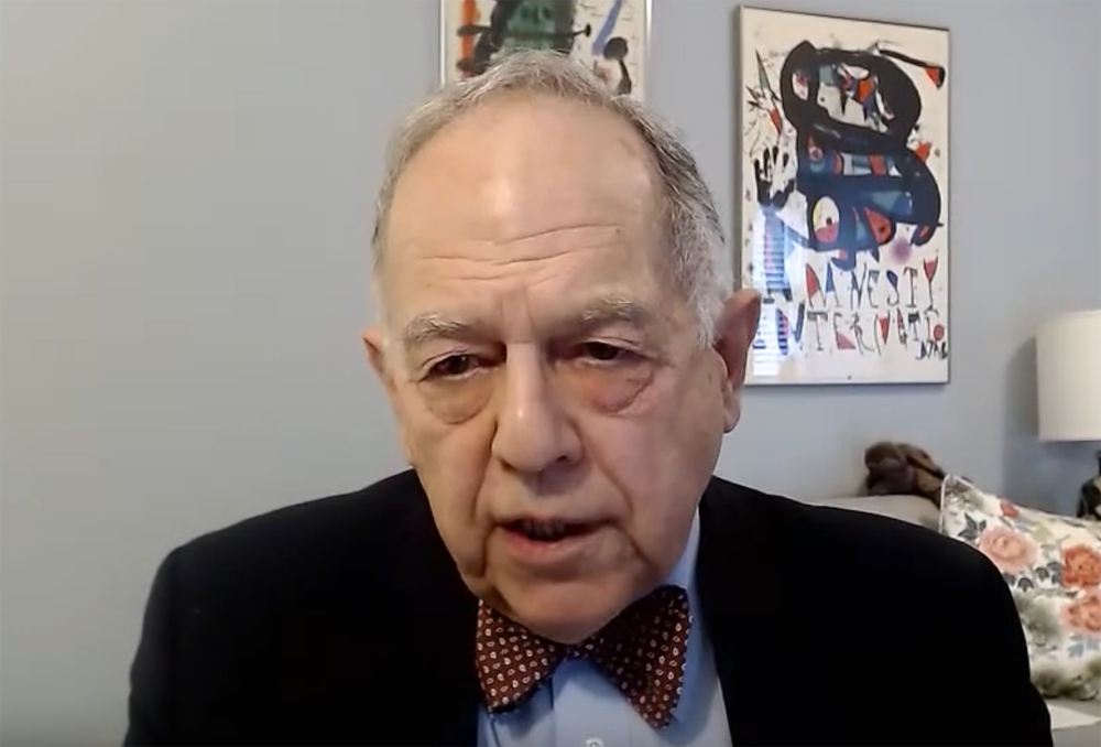 Man speaking in room with white background