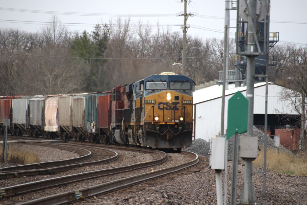 Train with blue and yellow locomotives rounds curve