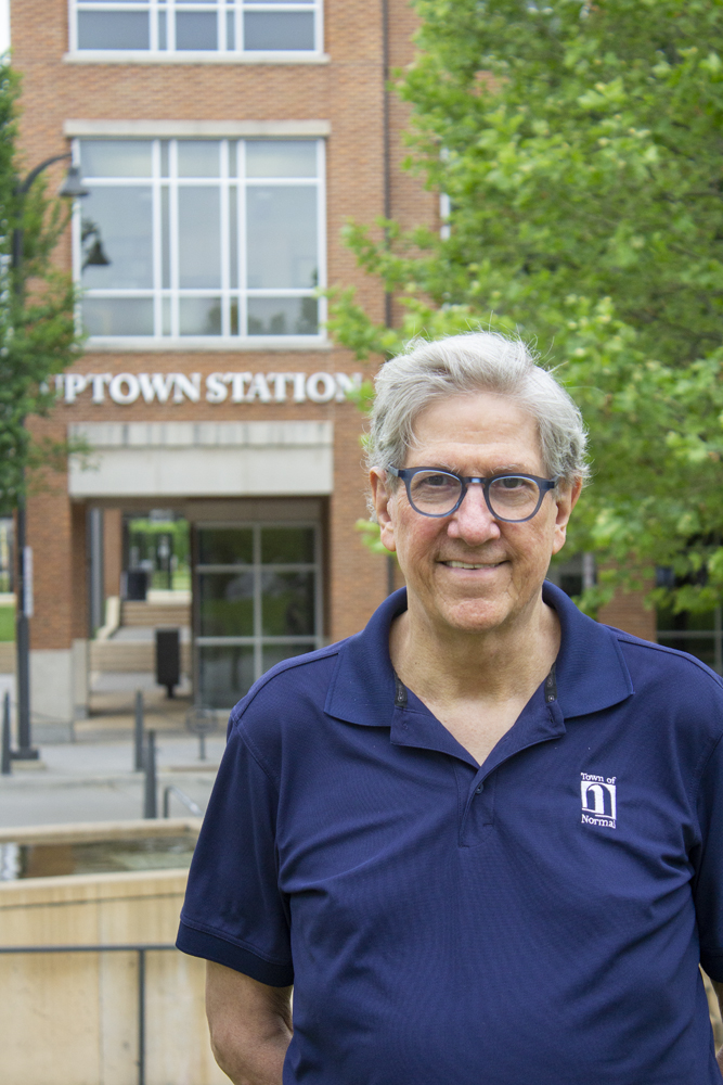 Man in blue shirt with brick building in background