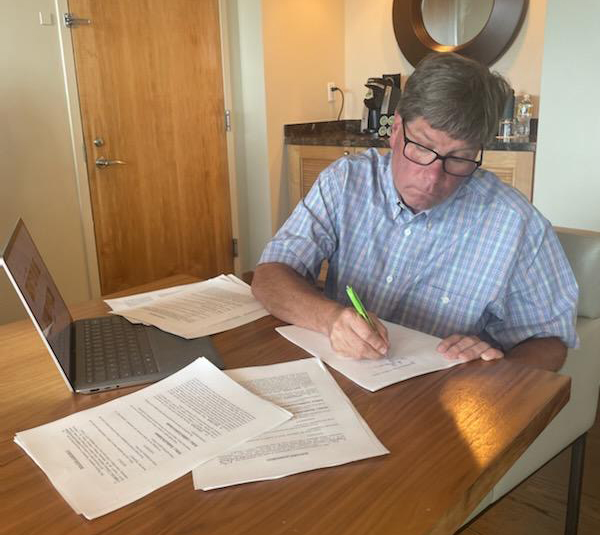 Man at table signing paperwork