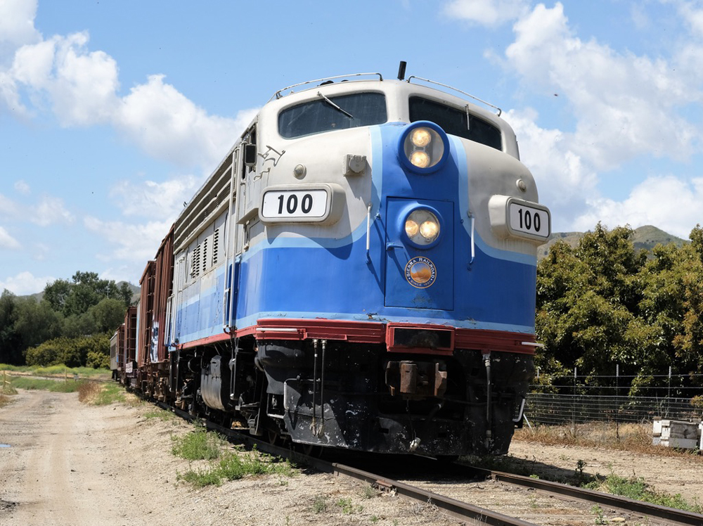 Silver and blue cab-unit diesel on train