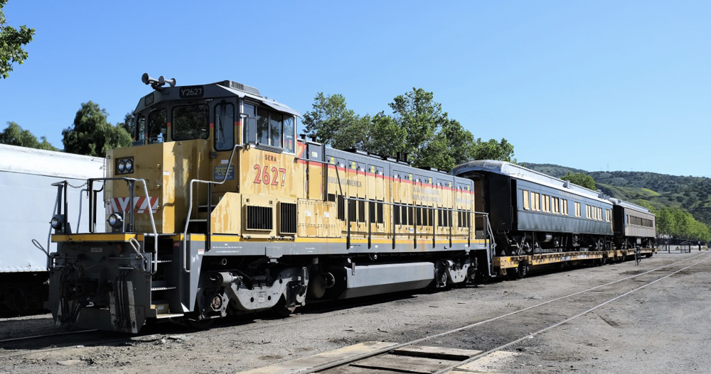 Locomotive with two passenger cars on flat cars