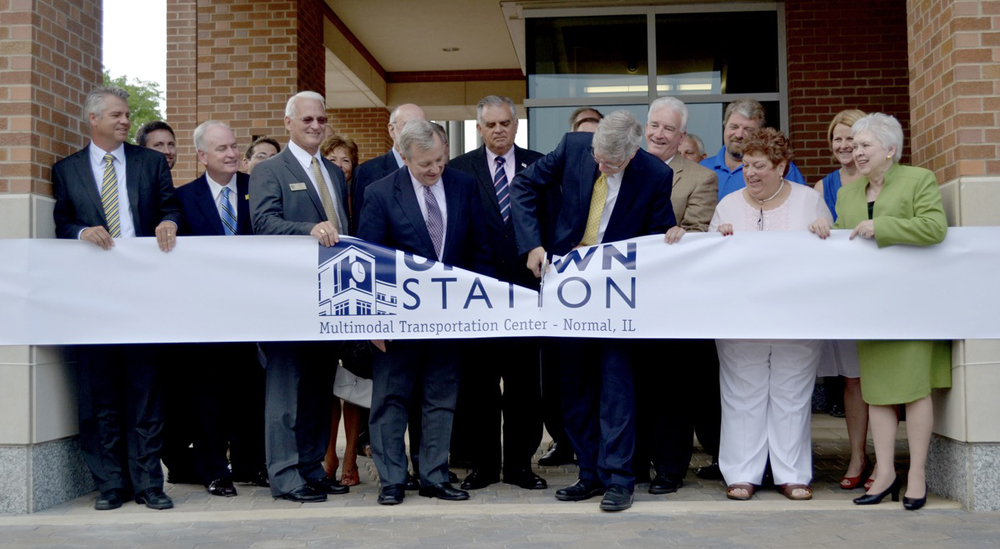 Large group of people at ribbon cutting ceremony for train station