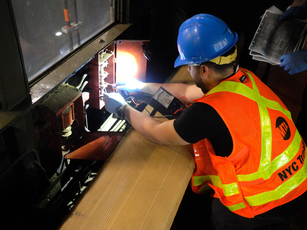 Man in orange vest working in electrical box