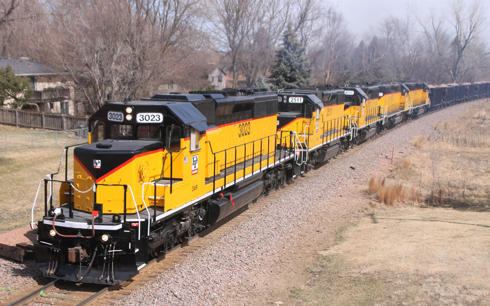 Yellow locomotives with black and red trim on freight train