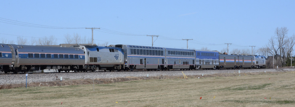 Passenger train including unusual mix of equipment and locomotive at mid-train