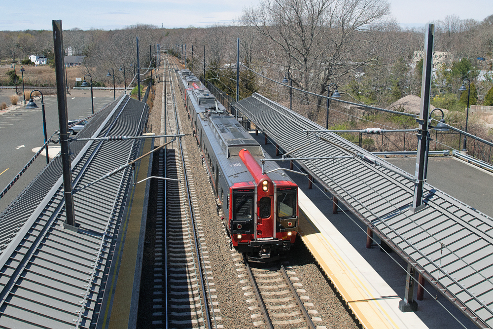 Electric multiple-unit trainset passes through station, as seen from overhead