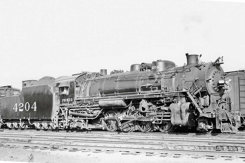 Steam locomotive in profile resting in yard