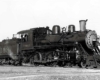 Engineer looks down from cab of steam locomotive with 183 on the tender