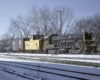 Black and yellow diesel locomotive on freight train with yellow caboose