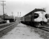 Streamlined locomotive at a small station.