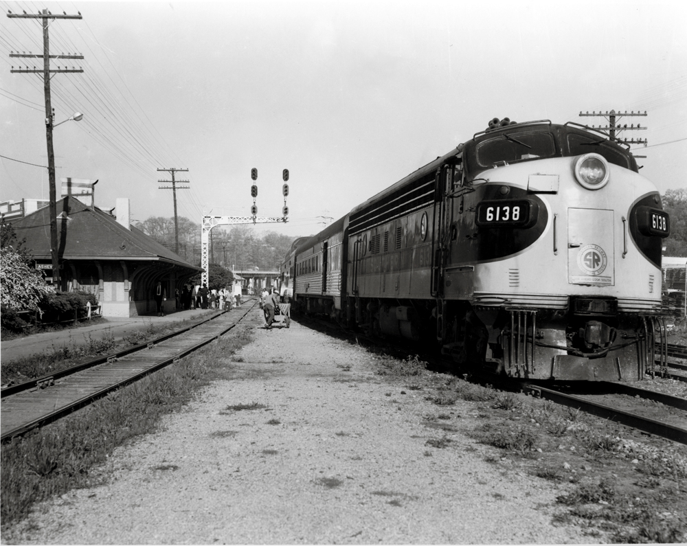 Streamlined locomotive at a small station.