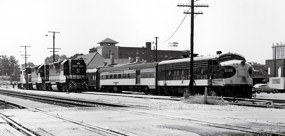 Steamlined locomotive with short passenger train at a station.