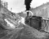 Rear view of a steam locomotive about to climb a steep grade. A runaway ramp is in the foreground.