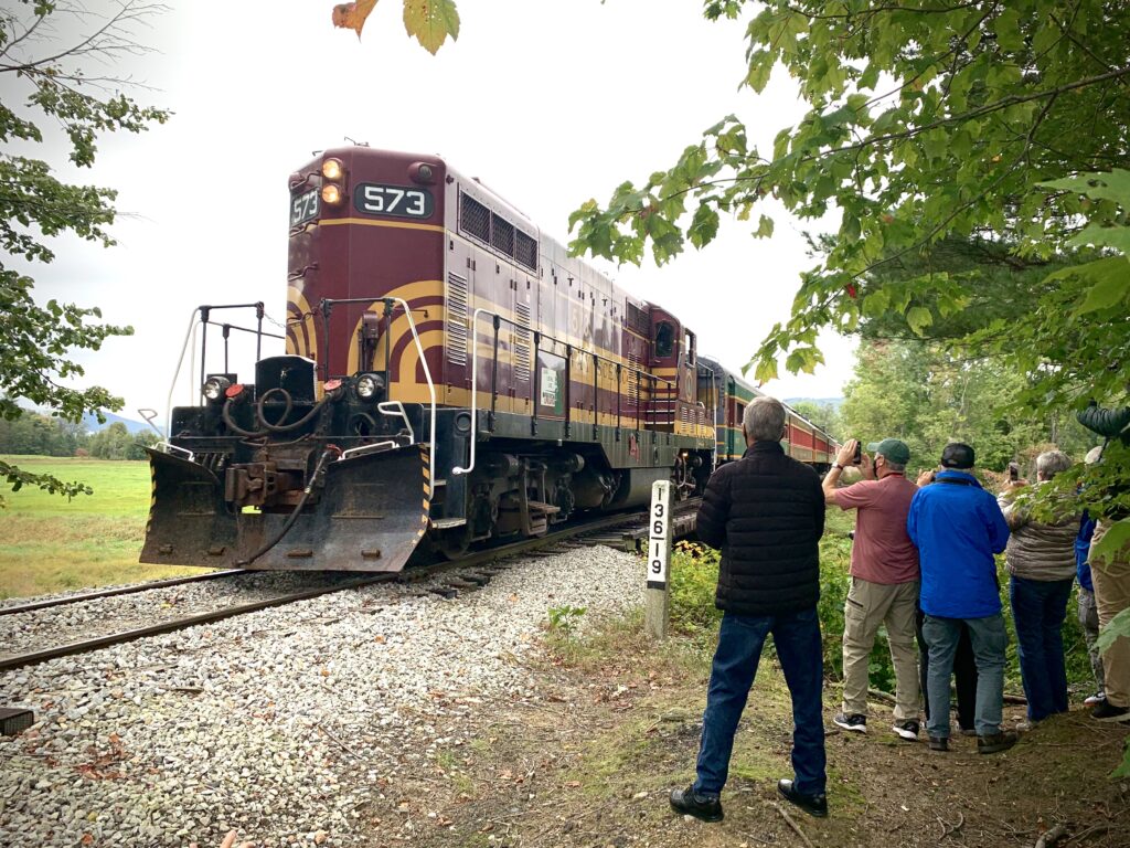 People standing trackside near diesel locomotive