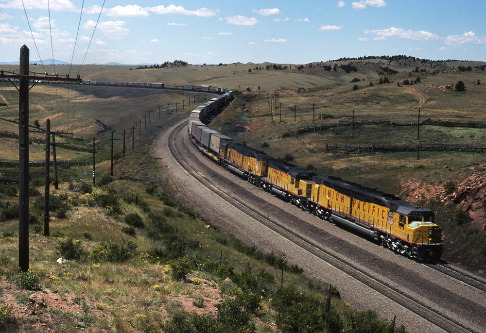 Yellow and gray EMD DDA40X diesel locomotives with another model
