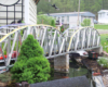 Silver bridge with conifer tree on garden railway