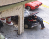 Model figure leans over a model car’s engine