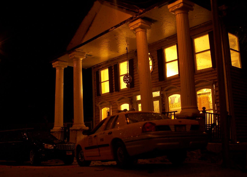 Night shot of a lit model structure with car in front of it