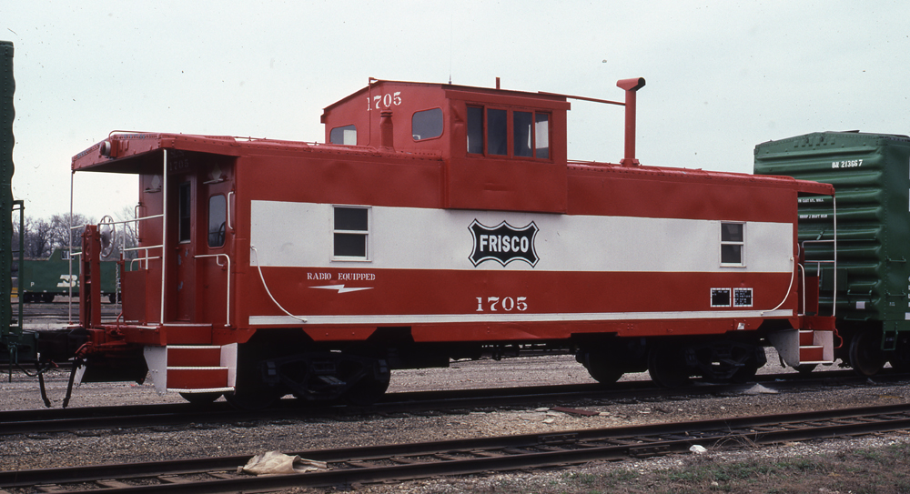 Photo of wide-cupola caboose painted Mandarin Orange and white.