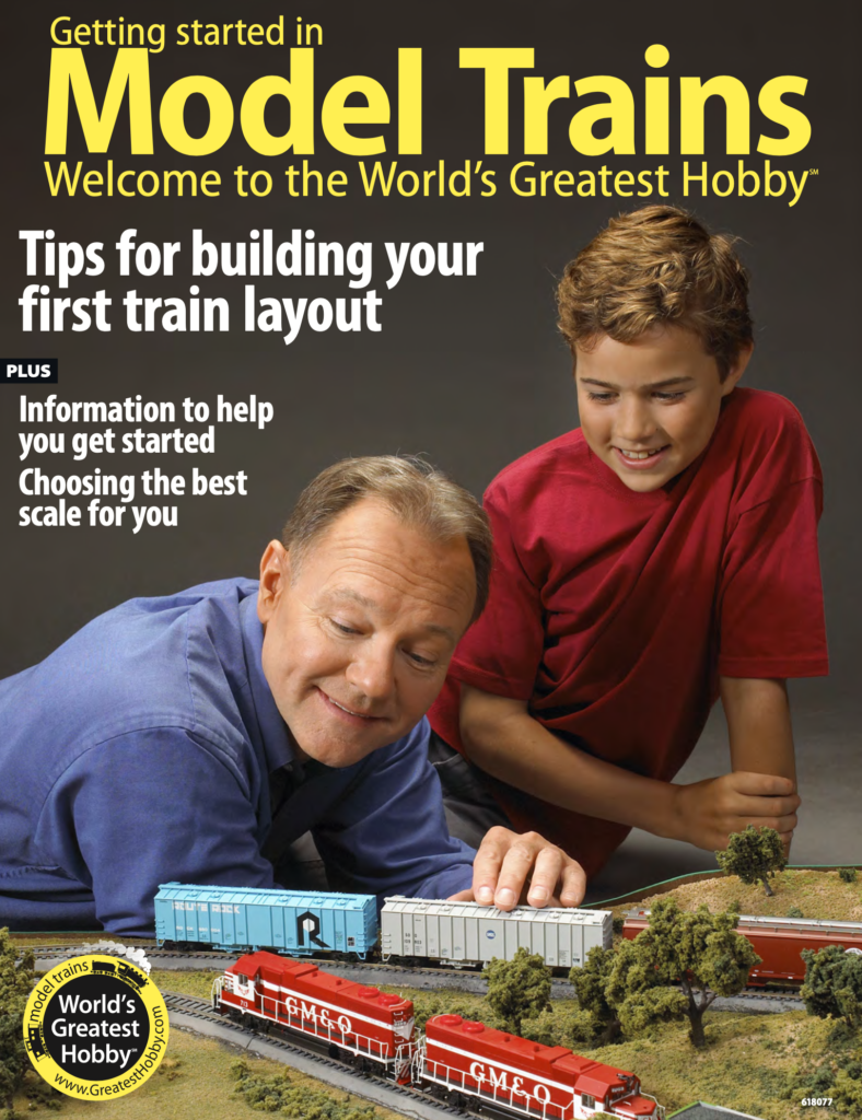 Man and small boy with a model train layout.