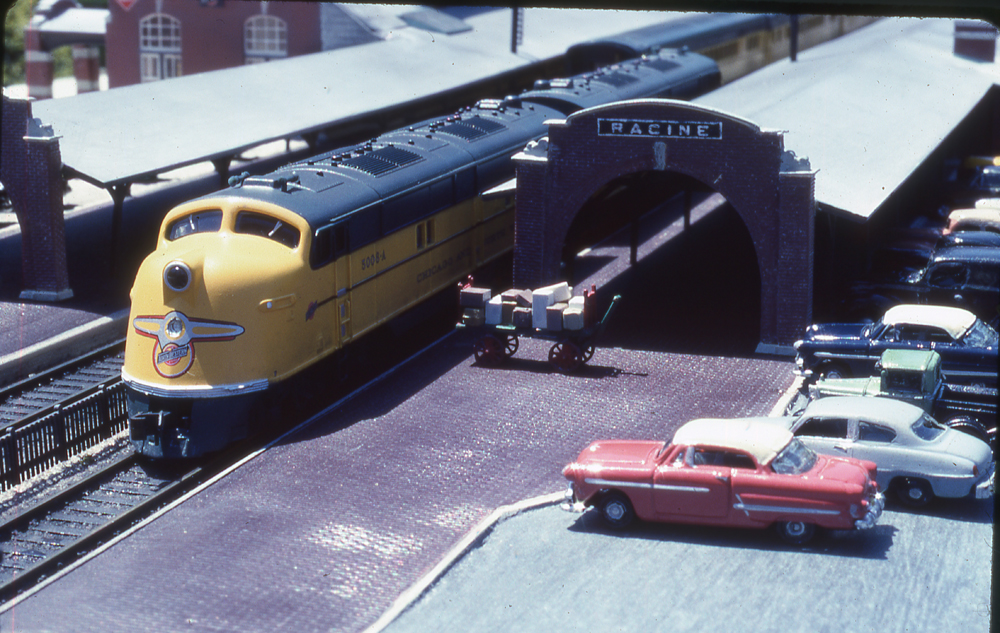 Two diesel locomotives stopped at a station on an N scale model railroad