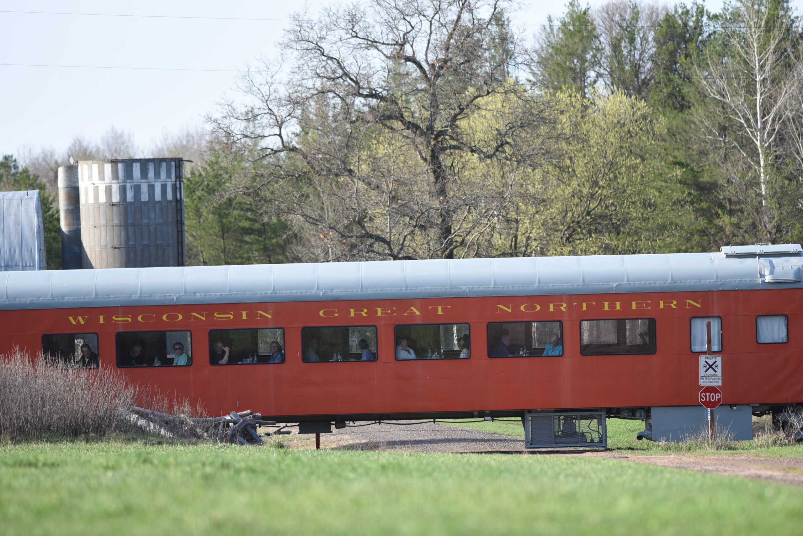 orange dining car passing a farm