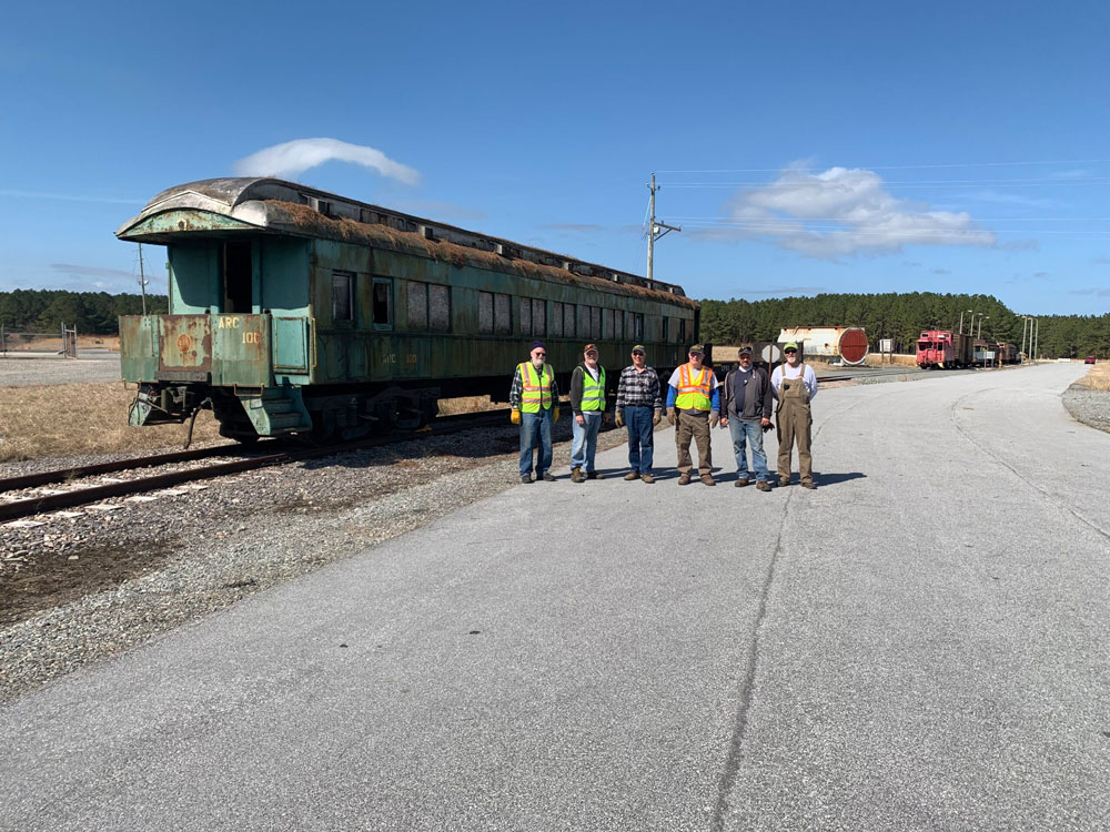 railroad workers next to track with passenger car