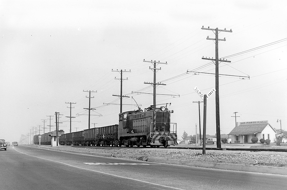 Baldwin locomotive with elongated carriage post hauling a freight train.