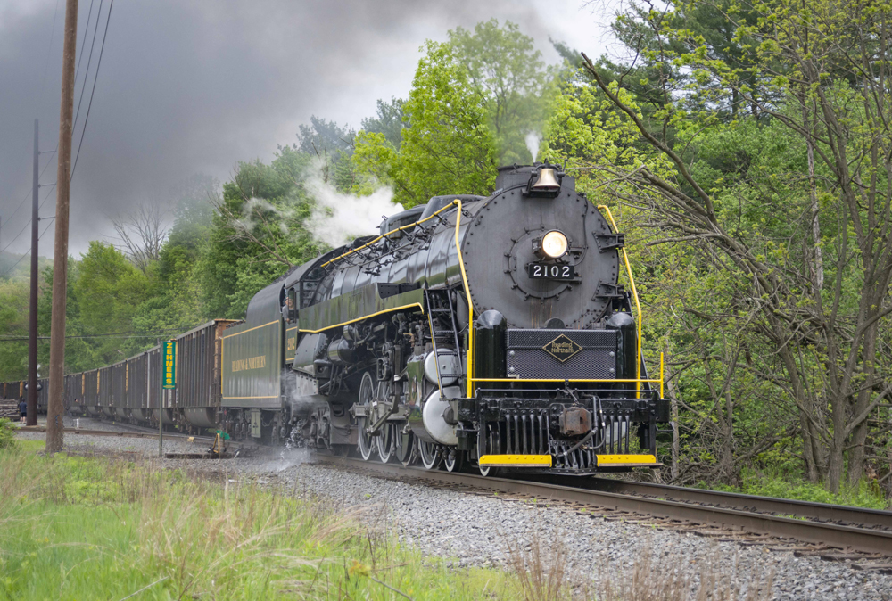 Steam locomotive towing hopper wagons