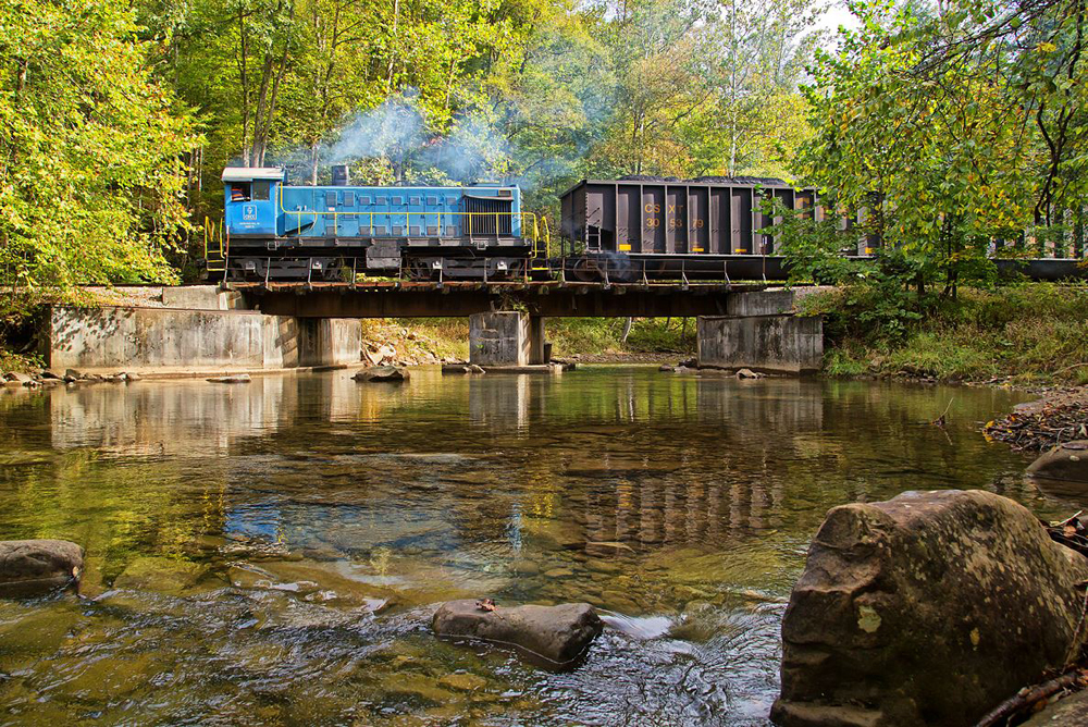Blue end-cab switcher moves coal hoppers across river