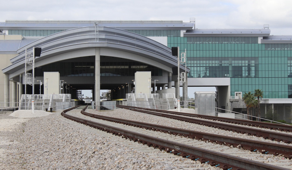 Railroad tracks leading into building with glass walls