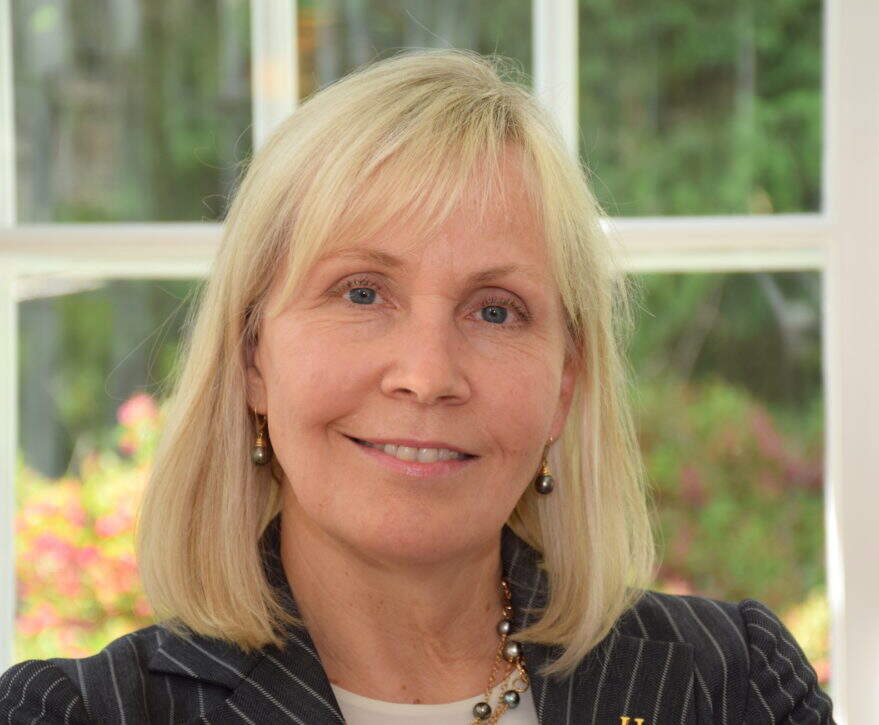 Woman with shoulder-length blonde hair seated in front of window