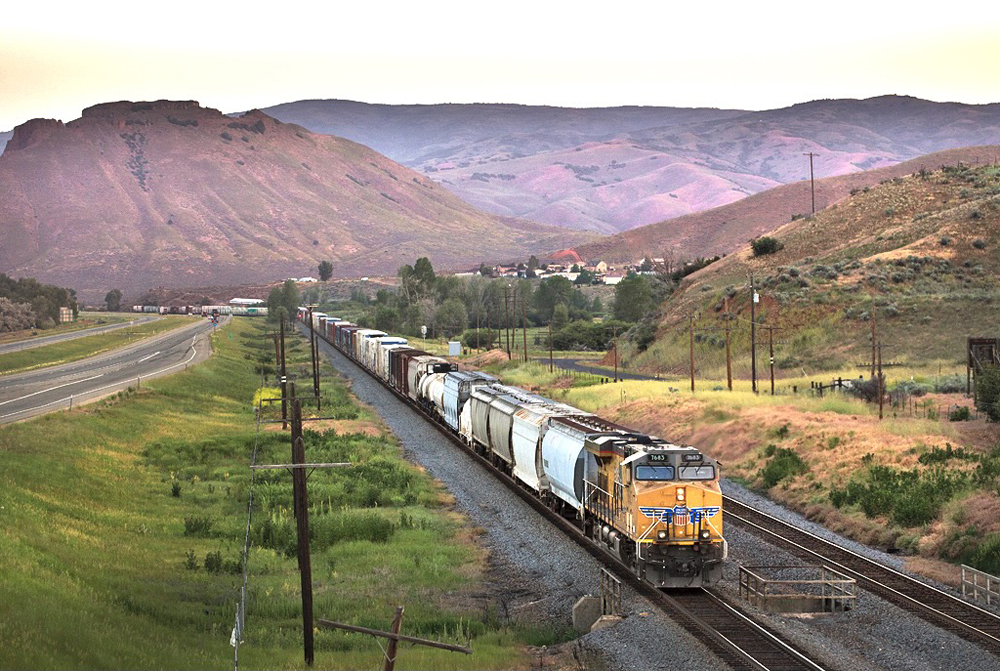 Freight train in valley at dusk