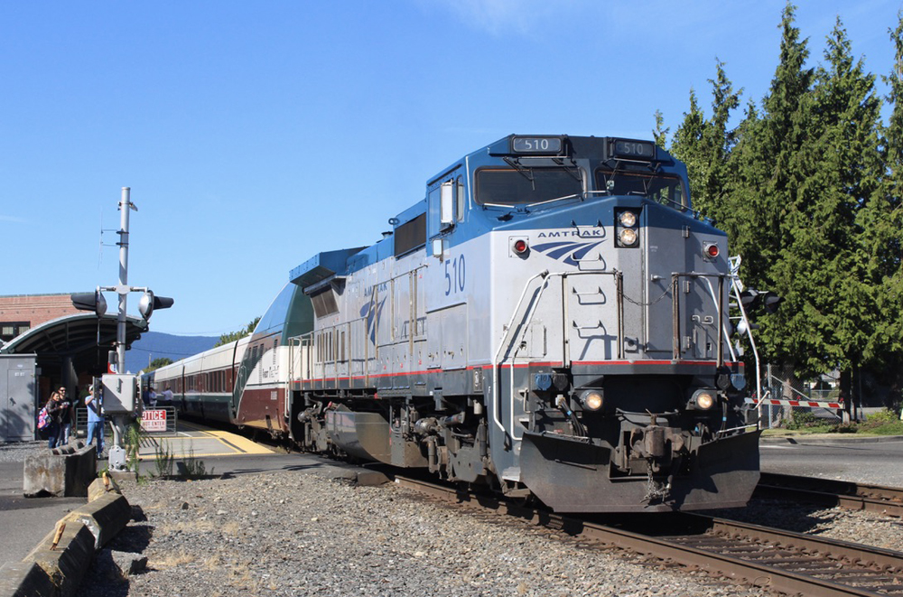 Blue and silver road-switcher locomotive on passenger train