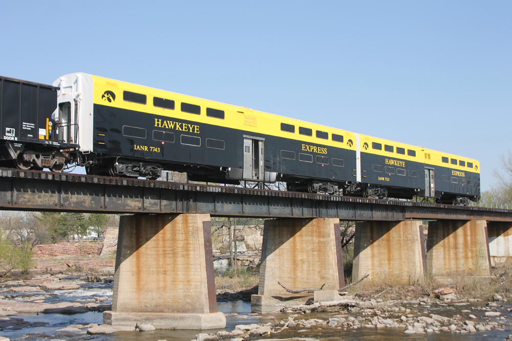Black and yellow bilevel passenger cars at end of train