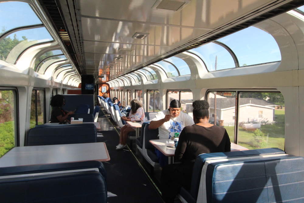 People sitting in car with curving glass at roofline