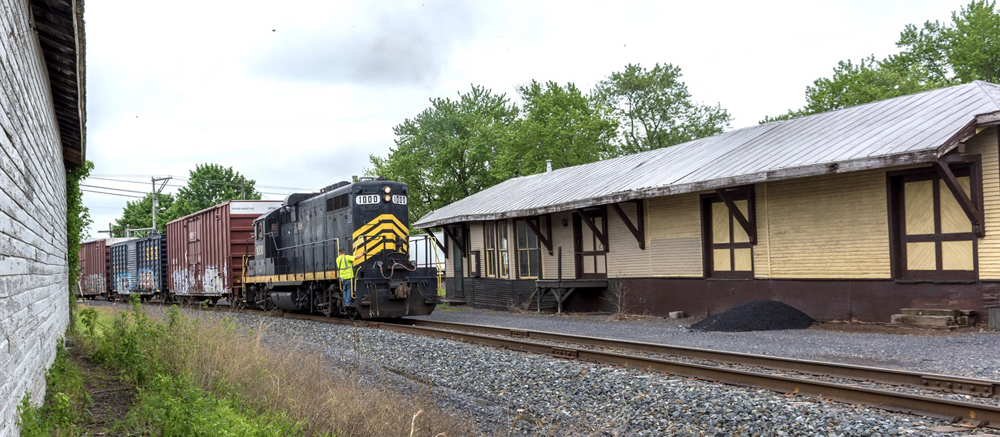 Train passes wooden railroad station