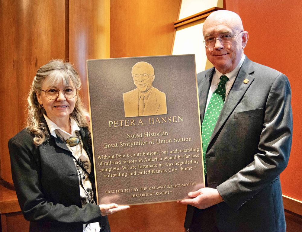 Woman and man holding plaque