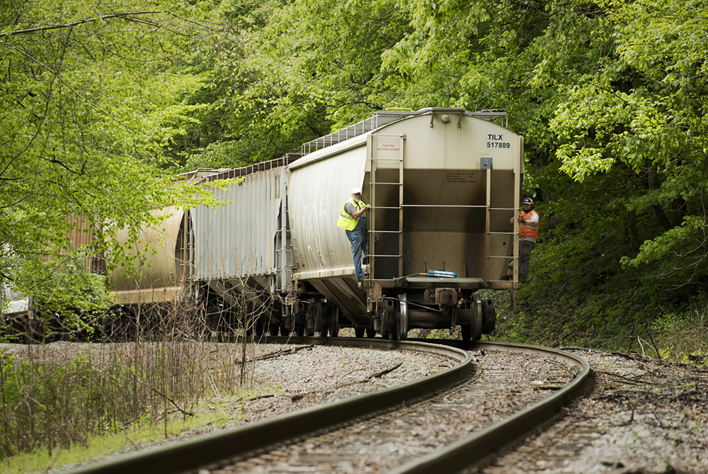 Rail workers riding on hopper car