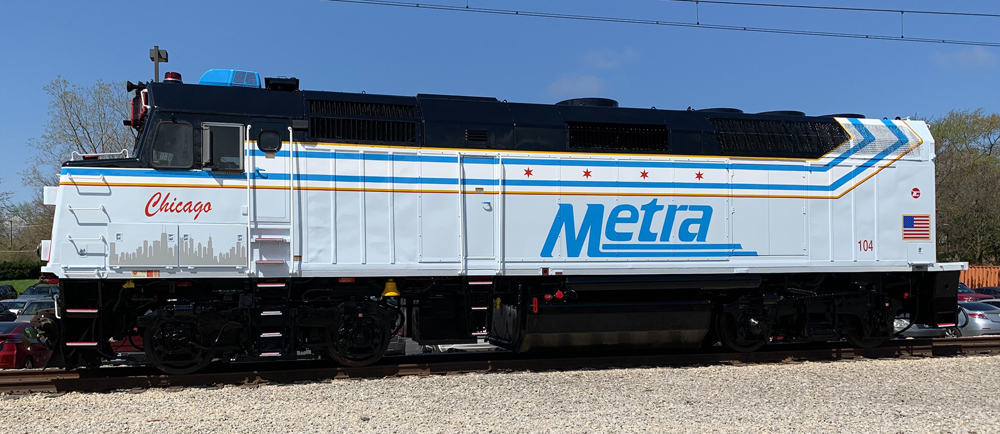 Locomotive in gray and white paint scheme with black, red, and blue trim