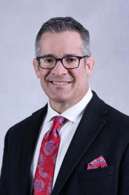 Portrait photo of man with black coat and red tie