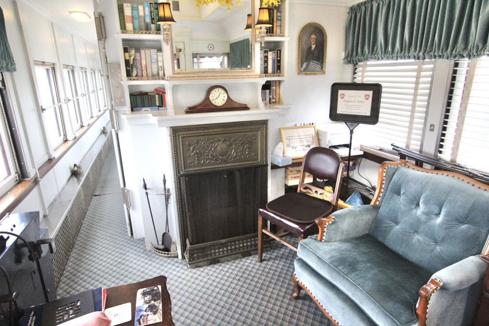 Interior of passenger car prominently including overstuffed blue chair