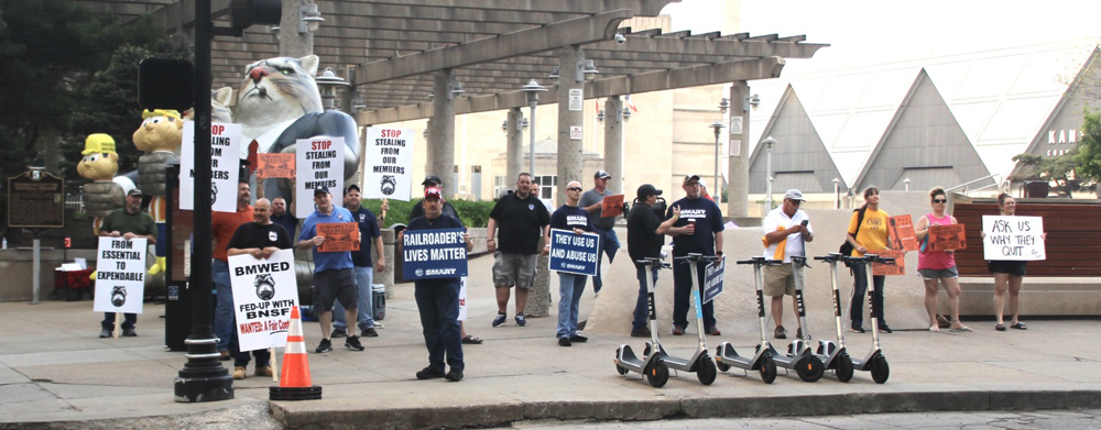 People with picket signs on sidewalk