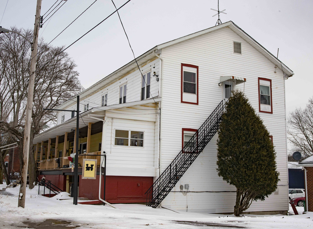 White wood-sided building in snow