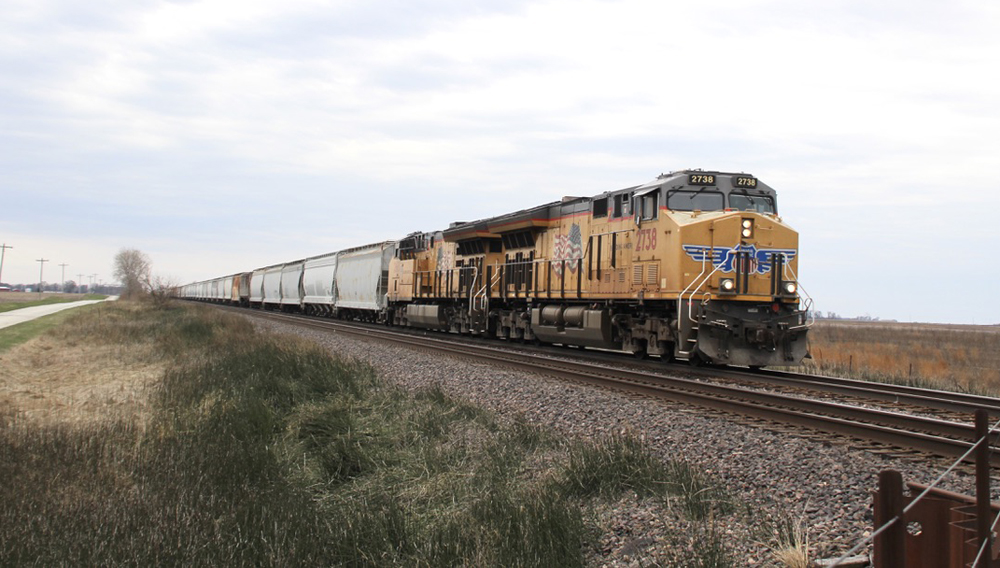 Train with yellow locomotives in flat area