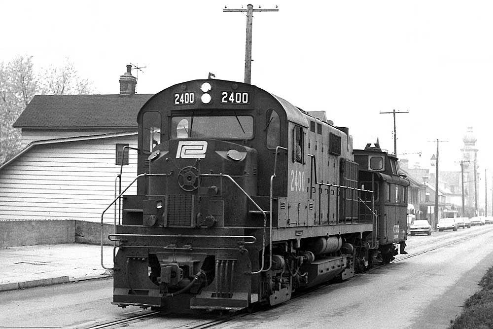 Diesel locomotive with caboose on street trackage