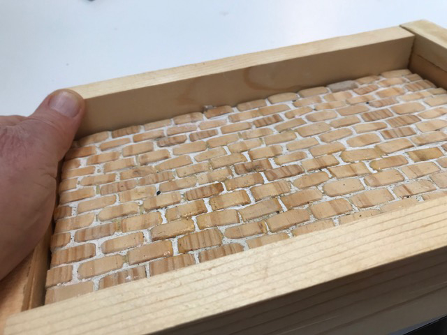Hand holding mold of paved street