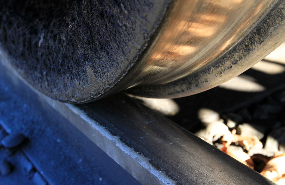 A close-up of a steel train wheel on a rail